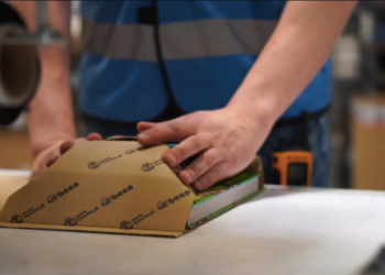 Pracownik serwisu TaniaKsiazka.pl pakuje książkę do wysyłki