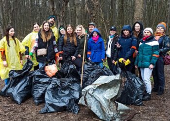 Pracownicy spółki Glosel posprzątali las, pracownicy w lesie z workami wypełnionymi śmieciami